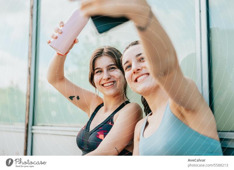 Two influencers making advertisements of sport products with their mobile phones,videos and selfies. lifestyle young person outdoor urban friends training