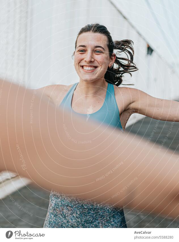 Young woman trainer teaching the different exercises to a student while they exercise with a smile. fitness female person young sport athletic lifestyle