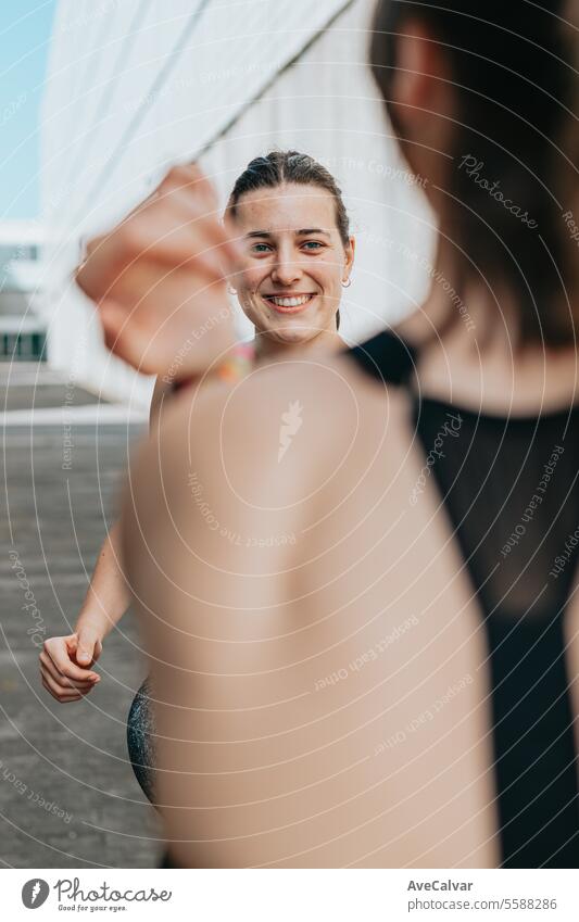 Young woman trainer teaching the different exercises to a student while they exercise with a smile. person lifestyles women adult fitness sport young happy