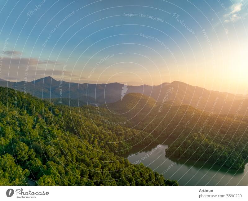 Beautiful landscape of green mountains and lake in the morning with sunrise sky. Nature landscape. Watershed forest. Water and forest sustainability concept. Aerial view of mountain with green trees.