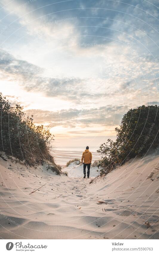 Traveler follows and presents events on the beaches of Dunkirk, France during World War II. A lone man in the sand dunes dunkirk scenery sunset freedom france