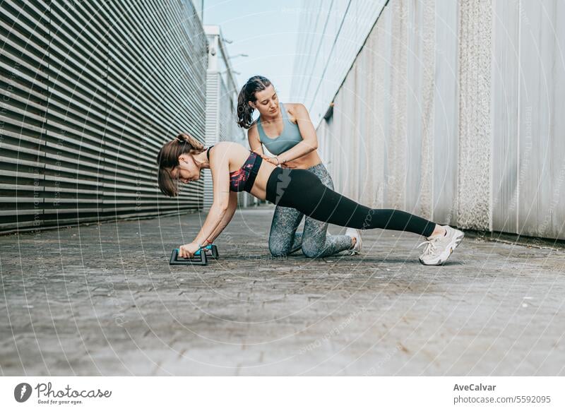 Young people exercising outside the home helping each other doing push-ups. Healthy life style. sport healthy training lifestyle outdoor urban friends young