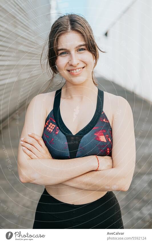 Happy jovial healthy young woman posing between building in urban environment with sporty atmosphere women female person beauty caucasian body portrait adult