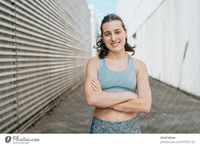 Portrait of a sporty, athletic and exercised smiling woman with her arms crossed in a street setting female beauty model women portrait person young adult happy