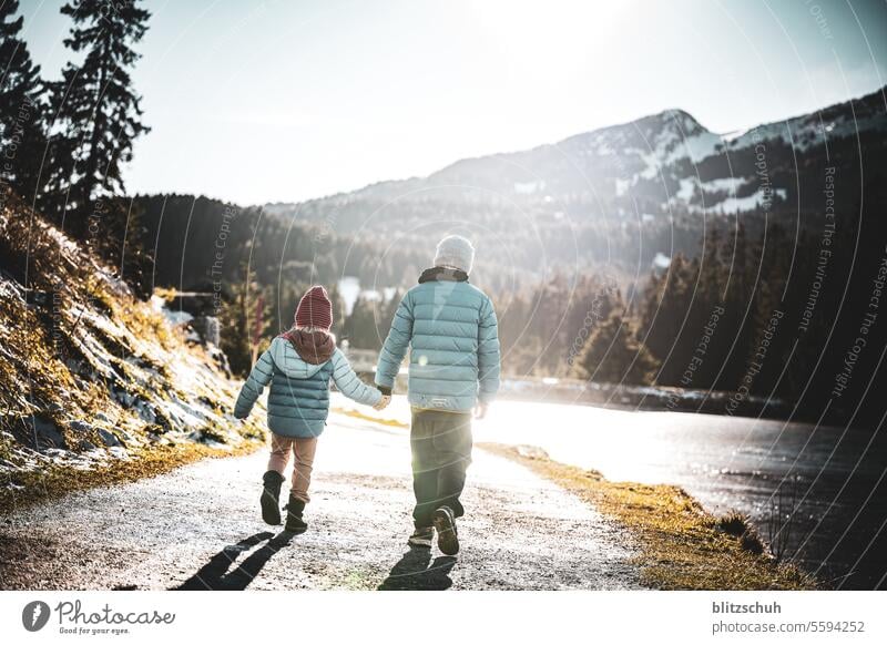 Two children walk together along the shore of a mountain lake on a beautiful November afternoon Brother Sister Brothers and sisters Walking Hiking Lake Girl