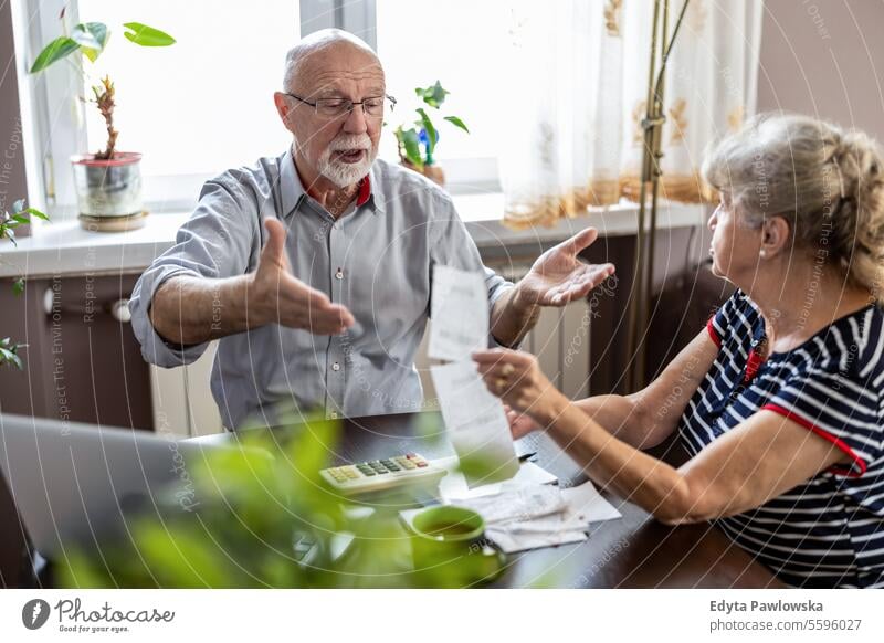 Senior couple discussing their home finances while sitting at the table real people woman senior mature female together Caucasian elderly house old aging