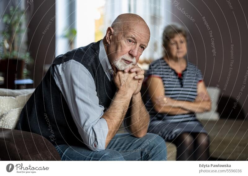 Senior couple sitting on sofa at home having a relationship problems real people woman senior mature female together Caucasian elderly house old aging