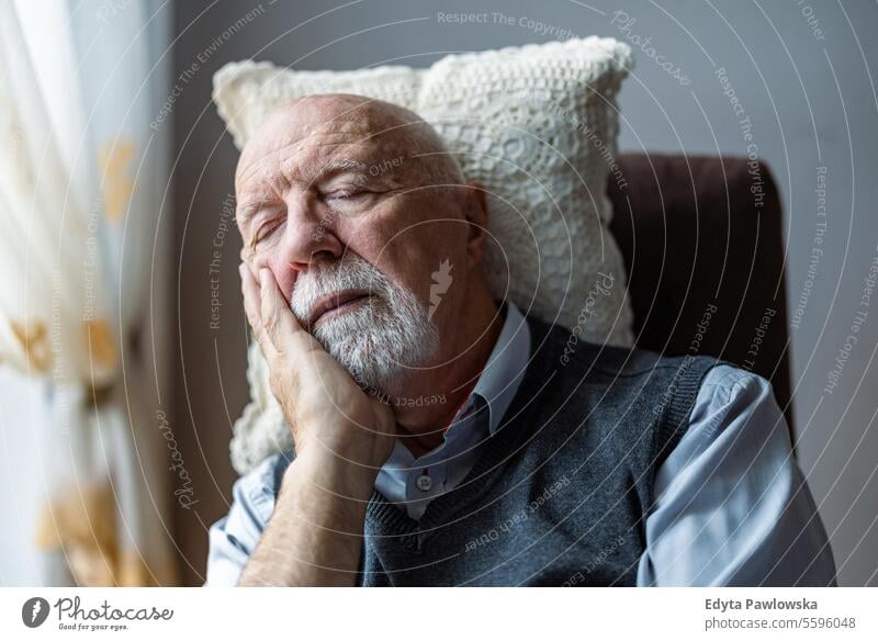 Senior man sleeping in an armchair at home real people senior senior adult mature male Caucasian elderly house old aging domestic life grandfather pensioner