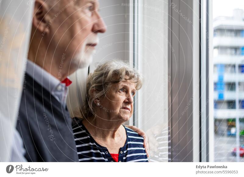 Portrait of senior couple looking out the window at home real people woman mature female together Caucasian elderly house old aging domestic life grandmother