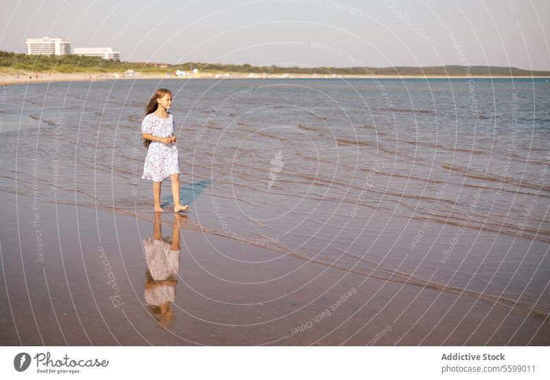 Child girl with long hair outdoors kid cheerful vacations relax sunset toddler rest seaside seashore seascape waves coastline adorable sunny enjoy freedom dress