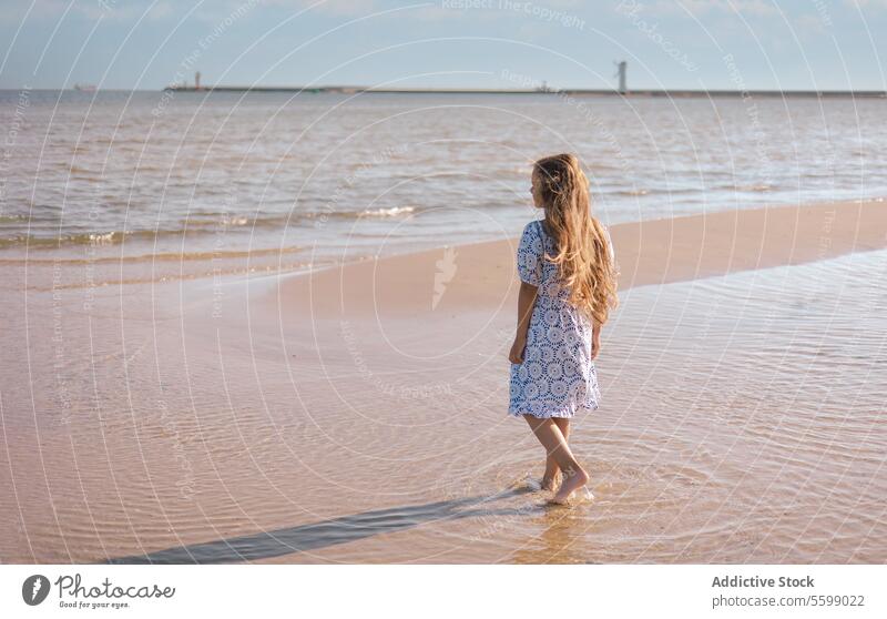 Seashore serenity girl dress sea horizon beach sand wave water shoreline pattern white standing hair clutch gaze serene ocean coast reflection sunlight shadow