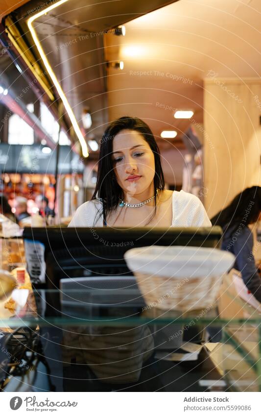 Woman using the screen of a cash register portrait woman sales assistant store business entrepreneur food bread cafe service bakery occupation owner cheerful