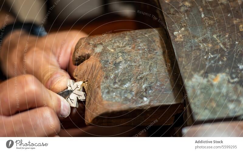 Goldsmith working and creating in his crafting gold jewelry workshop with a burin. Jeweler repairing a silver jewel. anvil close up craftsman design designing