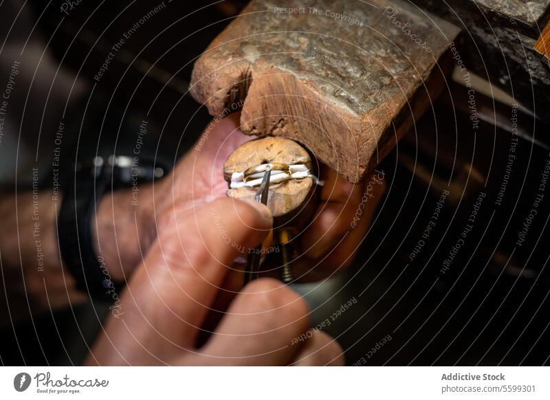 Jeweler hands setting a diamond into a ring with a burin in a jewelry workshop. Goldsmith working and creating a gold jewel. accessory art brilliant carat