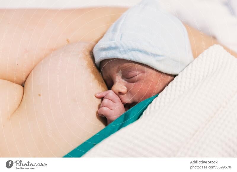 Cute newborn baby sleeping on his mother's chest in the hospital room. infant bed maternity birth childbirth warm bonding mom protect resting son asleep breast