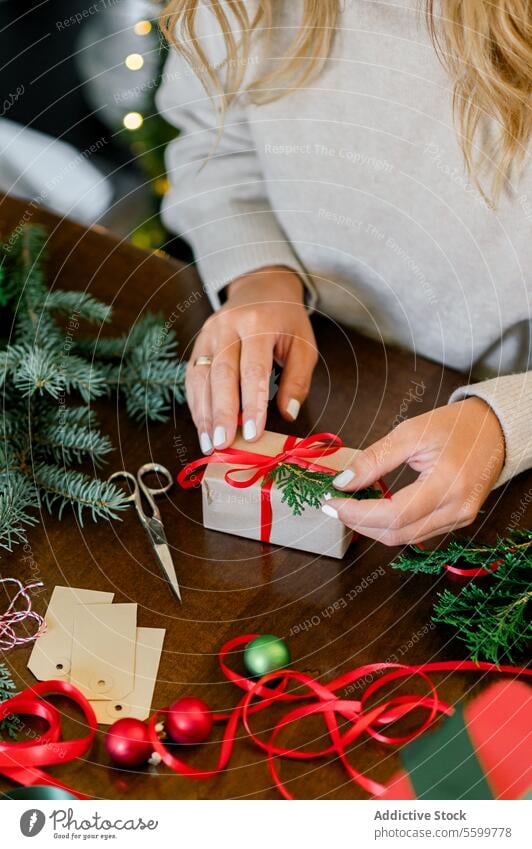 Woman making beautiful Christmas gift at table christmas person celebration present wrapping holiday hand box surprise red festive ribbon adult preparation