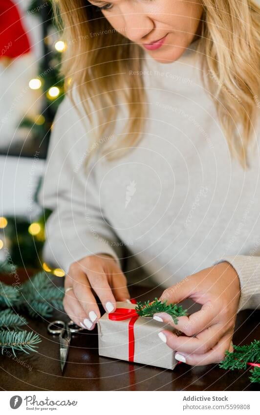 Woman wrapping beautiful Christmas gift at table christmas person celebration present holiday hand box surprise red festive ribbon adult preparation indoor