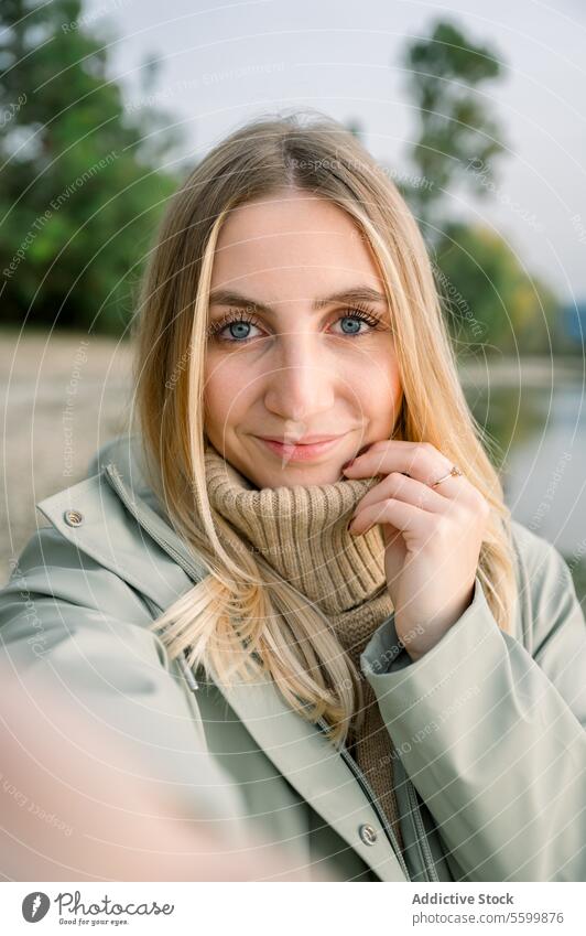 Smiling woman in coat looking at camera female smile style happy trendy cheerful young appearance positive city park joy urban street feminine outfit modern