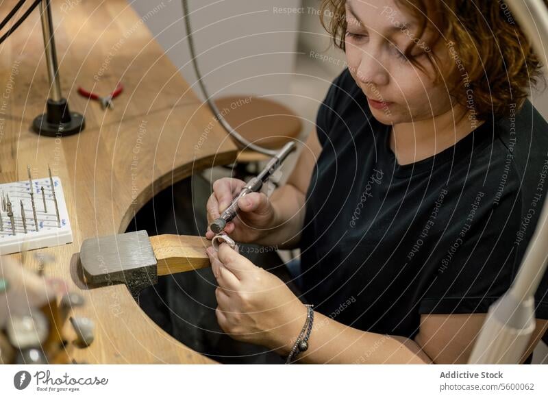 Focused adult craftswoman working in jewelry atelier occupation manufacturing expertise desk creativity photography one person skill businesswoman inspiration