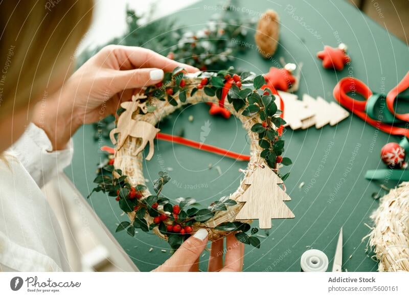 Woman holding Christmas wreath in hands person craft tradition diy female decorating creativity advent gift festive photography color image horizontal xmas