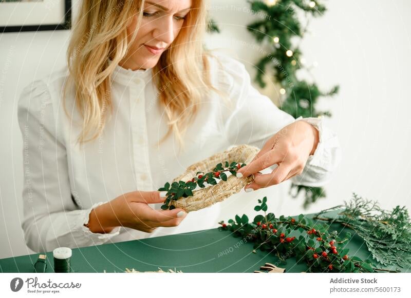 Making christmas wreath at home woman bauble xmas tradition hang festive branch new year decorate holiday inspiration merry atmosphere unrecognizable coniferous