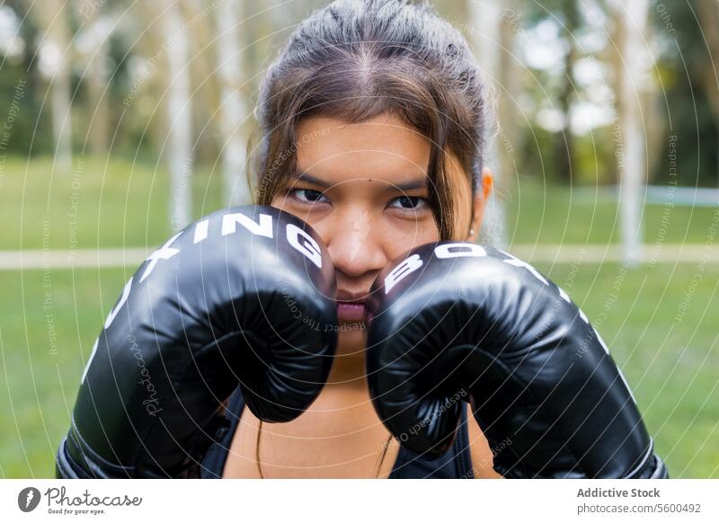 Boxer woman portrait wearing boxing gloves in a guard position active adult athlete black body boxer close up competition contact defense determination exercise