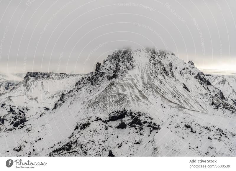 Aerial view of Expansive Snowy Mountain Range snowy mountain range panoramic snow-covered expanse intricate pattern rock brooding sky landscape nature winter