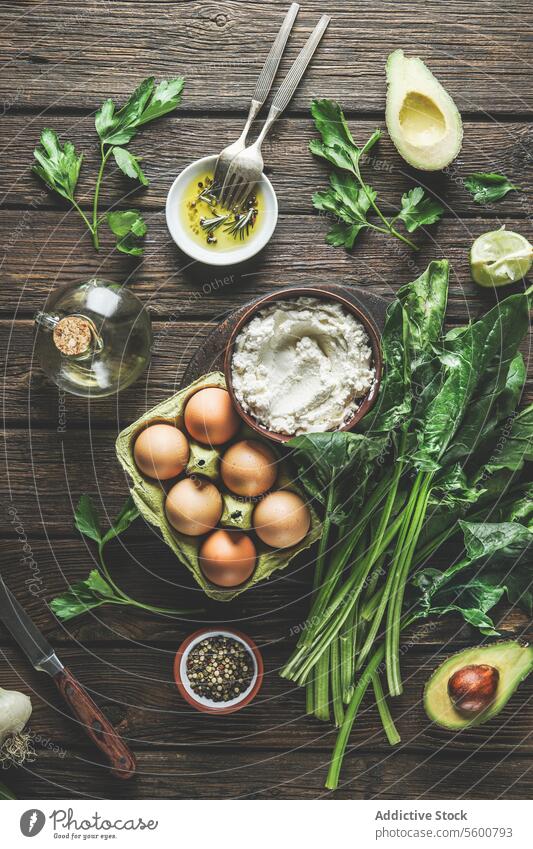 Preparing spinach ricotta stuffing with herbs, eggs and spices at dark wooden kitchen table. Cooking at home with fresh healthy ingredients. Top view. preparing