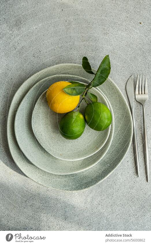 Citrus Fruits on Stacked Ceramic Plates citrus fruits ceramic plates stacked modern kitchen aesthetics natural elements overhead lemon lime green yellow