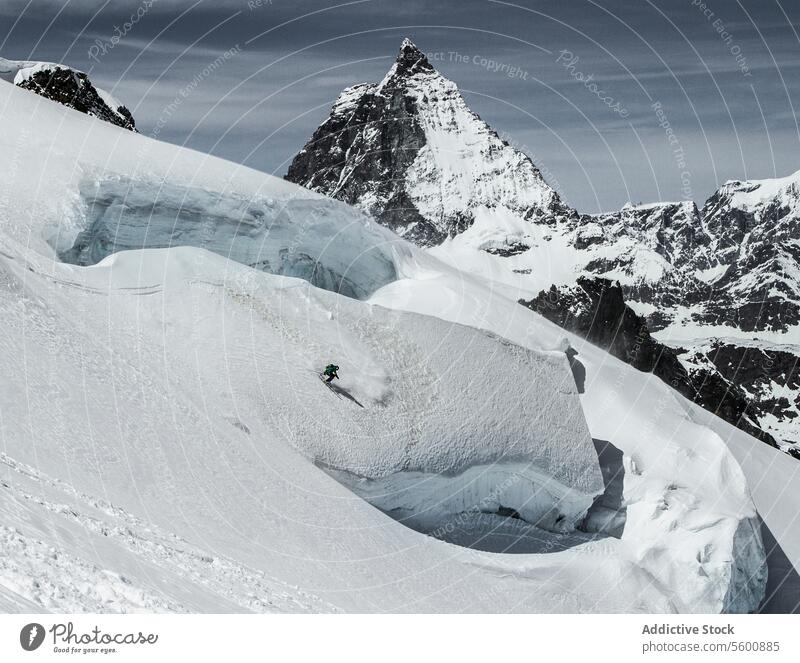 From above of anonymous snowboarder practice from mountain in winter day at Swiss Alps landscape swiss alps snowy slope rock sunny covering top natural nature