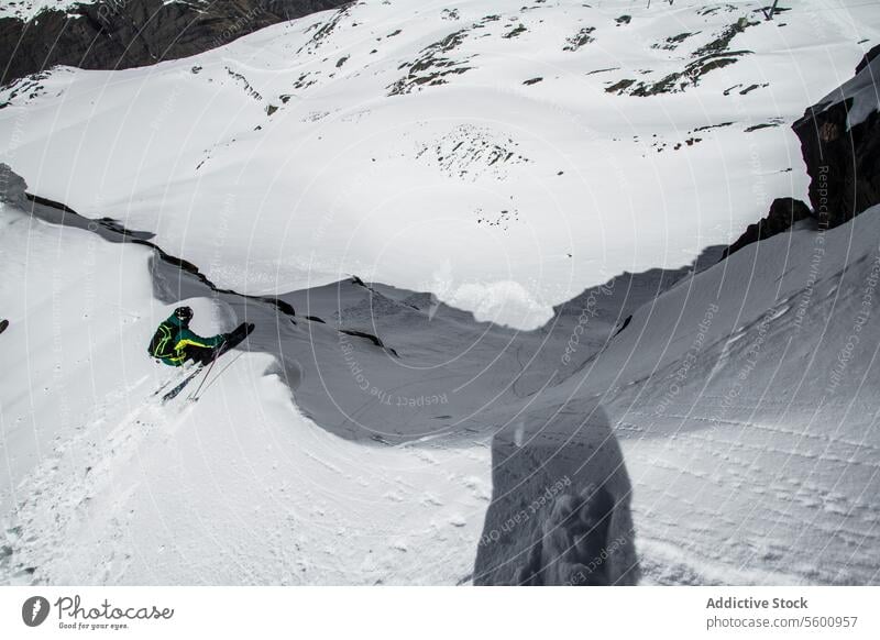 From above of anonymous skier skiing on snowy slope on winter day on resort at Swiss Alps sport mountain sunny from above enjoy vacation covering swiss alps