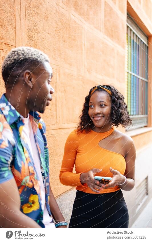 Young black friends walking in the street young couple smiling happy lifestyle outdoor urban casual man woman portrait person city adult communication outdoors