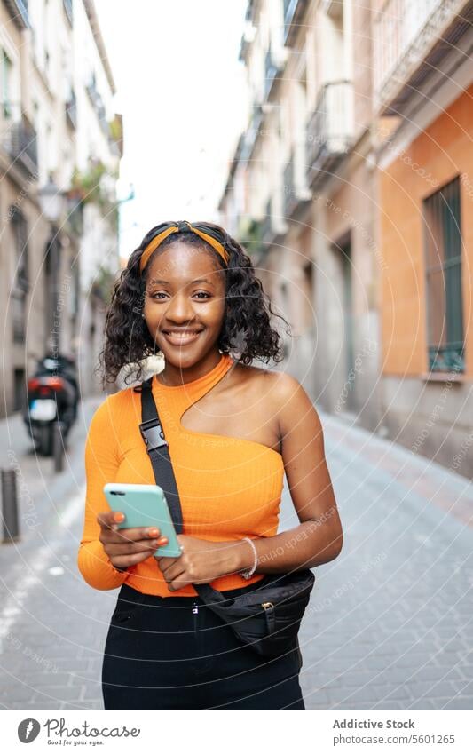 Portrait of a young black woman using smartphone in the street lifestyle happy technology texting smiling mobile person portrait beautiful girl adult