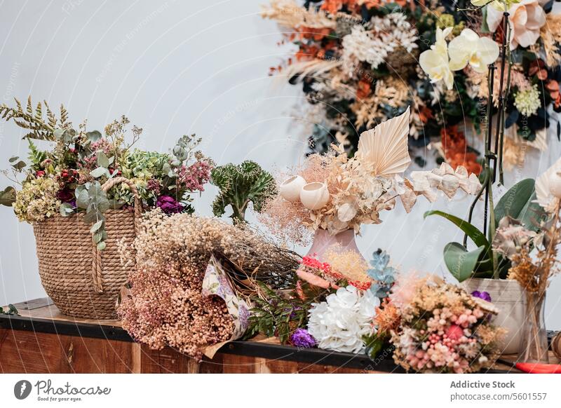 Floral Arrangement Display on a Wooden Reception Desk arrangement desk flowers wooden cash register decoration dry interior design modern workspace basket