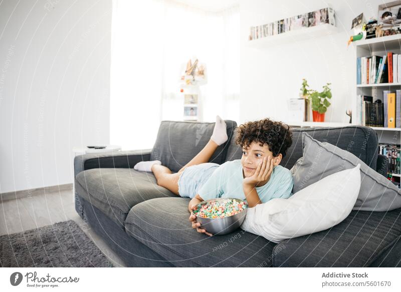 Girl watching tv in living room Family Preteen daughter Tv adorable cheerful child childhood children couch cute female fun girl happiness happy home indoors