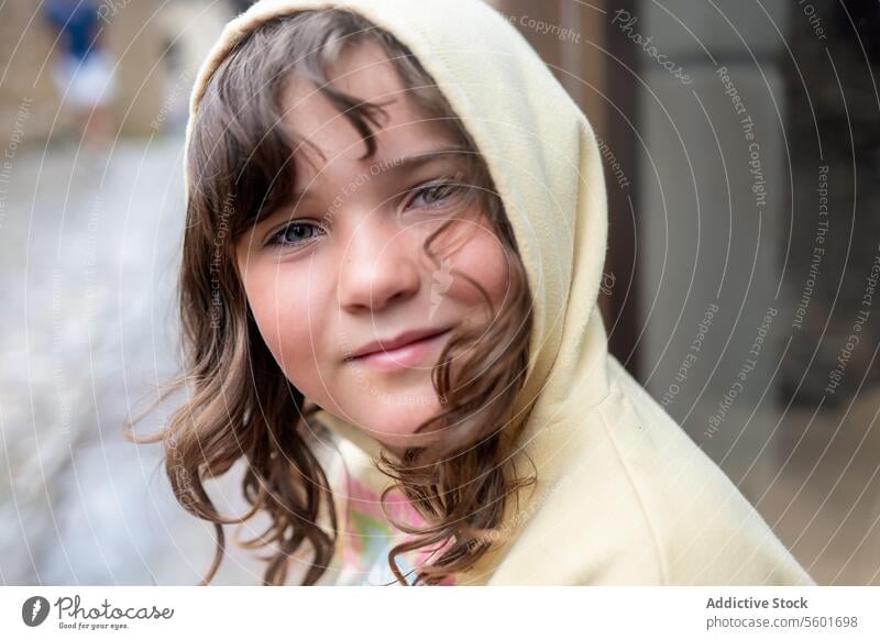 Smiling child girl with hood looking at camera Child smile portrait outdoor rain happy youth kid cheerful innocence joy face casual clothing cute childhood