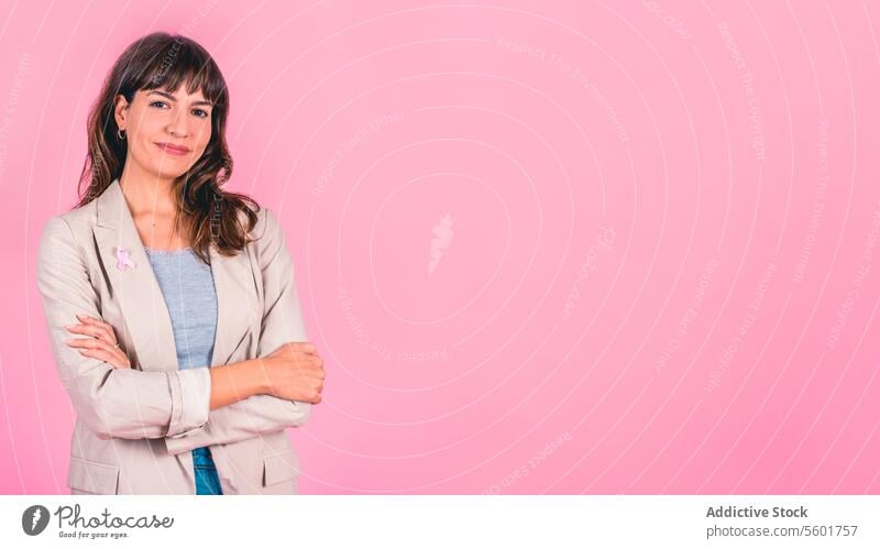 Smiling woman wearing a pink breast cancer awareness ribbon on her coat. Copy space Breast Cancer Awareness Breast Cancer Month Breast cancer prevention