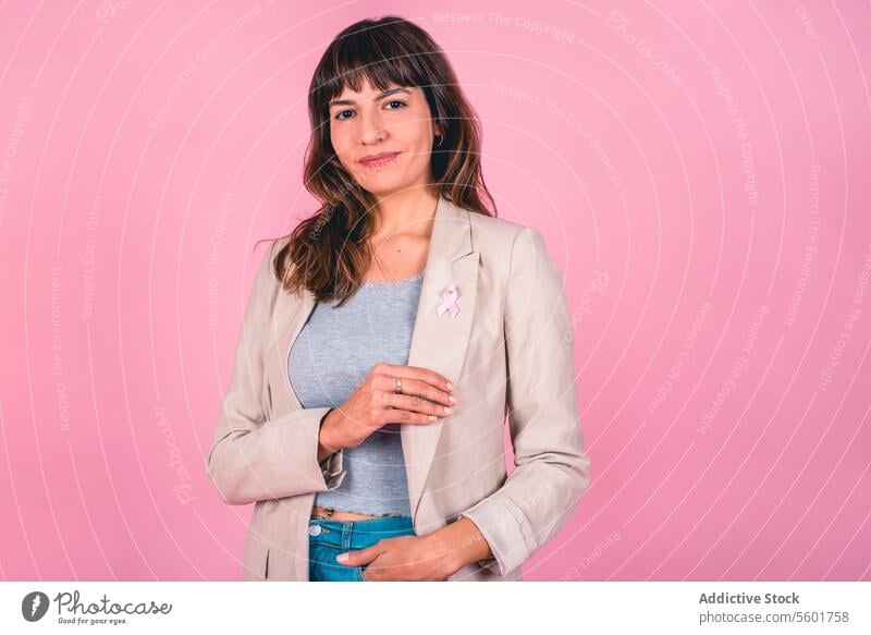 Beautiful woman wearing a pink breast cancer awareness ribbon while showing it. Breast Cancer Awareness Breast Cancer Month Breast cancer prevention