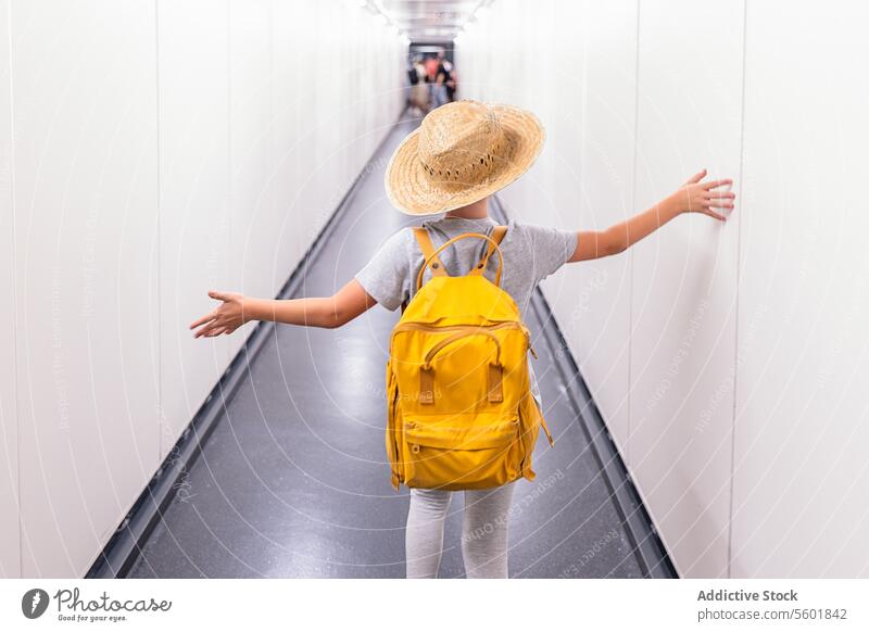 Faceless boy traveling at airport terminal anonymous backpack hat arms outstretched boarding back view walking faceless vacation holiday tourism straw