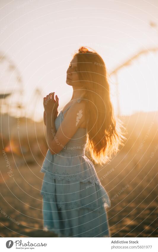 Serene sunset moment at Santa Monica Pier woman serenity santa monica pier tranquil ferris wheel silhouette los angeles soulful contemplation peace backlight