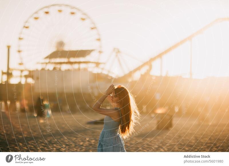 Sunset stroll near Santa Monica Pier woman sunset santa monica pier ferris wheel silhouette golden hour los angeles usa beach serenity calm summer