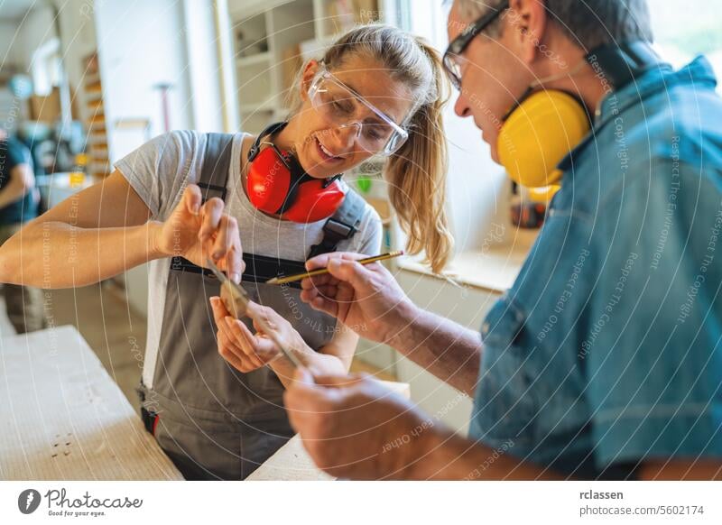 Carpentry mentor and apprentice measuring a wooden piece in a well-lit workshop professional craftsman workbench furniture industry worker wooden timber