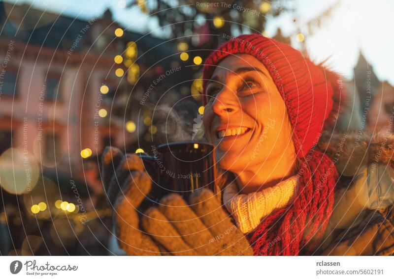 Beautiful woman drinking mulled wine on Christmas market steam december hot chocolate xmas switzerland austria munich food hangout winter bokeh christmas tree