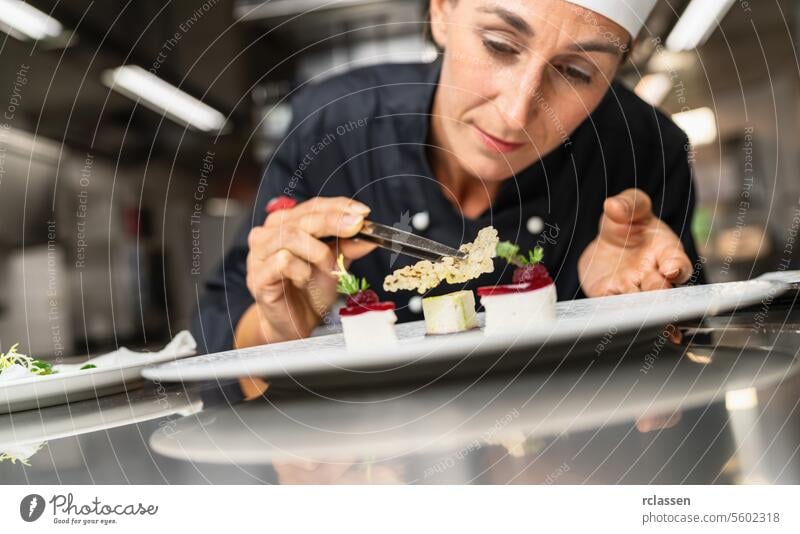 Chef Perfecting a Gourmet dessert adding rice chip topping finishing dish, decorating meal in the end. Luxury hotel cooking concept image. trendy sugar art