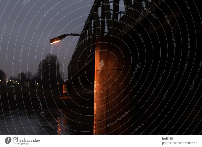 sparsely lit water level indicator on a bridge pier at the blue hour water gauge Twilight Inland navigation Lighting Water level Bridge Bridge pier