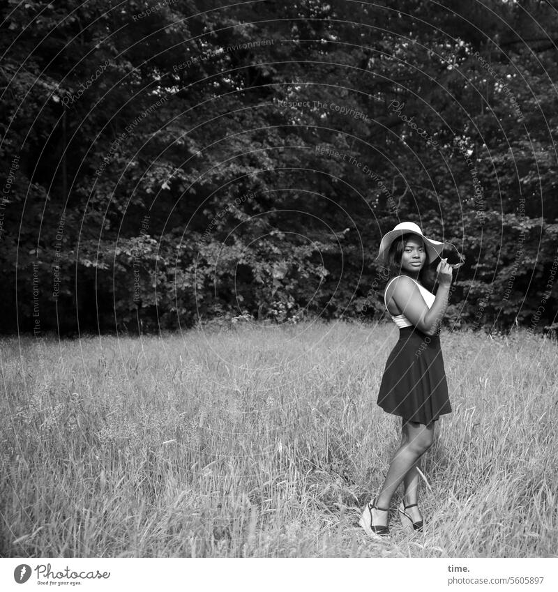 Woman with hat on a meadow portrait whole body Hut Meadow Rock Edge of the forest Stand Arm posture feminine Long-haired look Dark-haired Sunglasses heels Dress