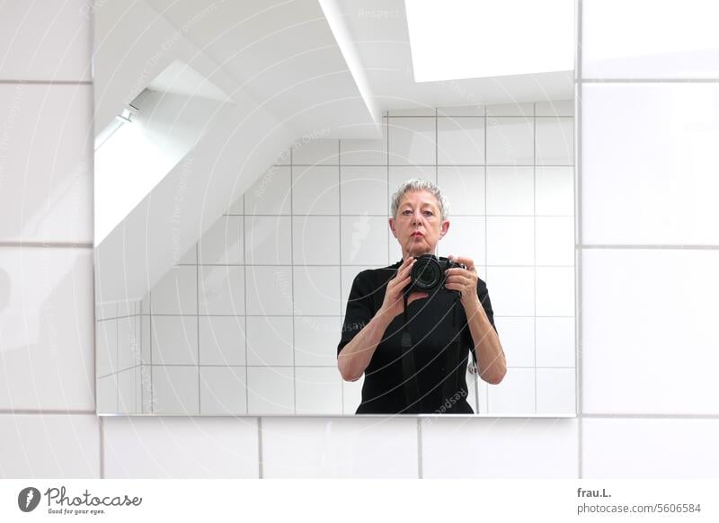 Selfie in color photo Woman portrait Face Old see Bathroom camera Mirror Mirror image Window Skylight tiles gray hair crease age spots Drooping eyelids