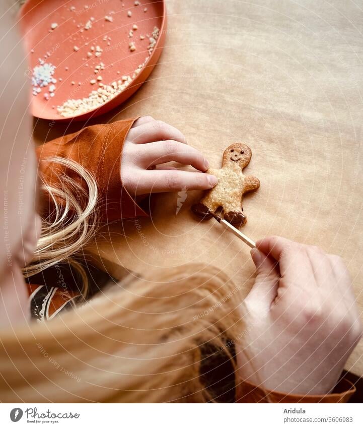 Child creates a little cookie man with chocolate candy Baking cut out cookies outdo sb. Anticipation Hand pre-Christmas period nibble baking paper bake cookies