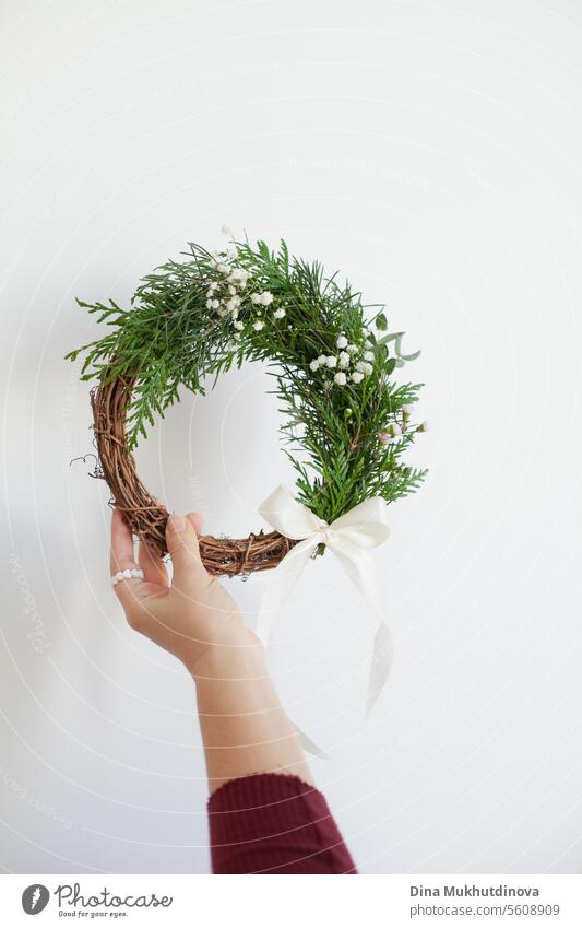 hand of female florist holding spring wreath home Easter decoration. Springtime floristry. Floral decor. easter springtime flowers background blossom nature