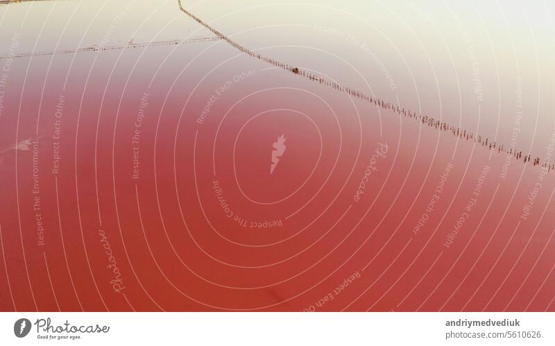 Aerial view of salt lake with pink water, lagoon Sivash, Ukraine, recreation place. Lake naturally turns pink due to salts and small crustacean Artemia in the water.